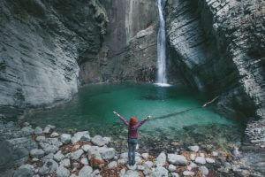 Woman standing in front of a waterfall