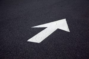 Painted white direction arrow on tarmac